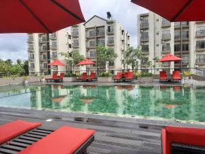 a large swimming pool with red chairs and buildings at Elixia-Colombo,Malabe in Colombo