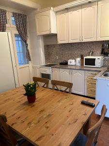 cocina con mesa de madera y armarios blancos en B17 apartman en Budapest