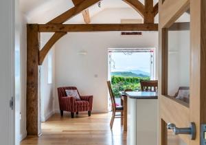 a kitchen with wooden beams and a table and chairs at Bryn Eithin in Derwen