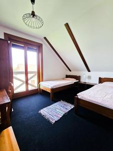 een slaapkamer met 2 bedden en een groot raam bij Gościniec Gryszczeniówka in Wargowo
