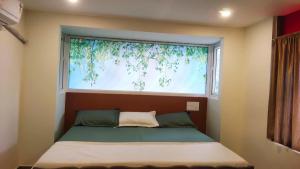 Pallipuram的住宿－Ambadi's Homely Retreat，一张位于带大窗户的房间内的床铺