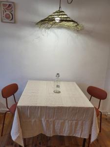 uma mesa com um copo de vinho e duas cadeiras em Aux portes du Palais - garage à vélo - em Hauterives