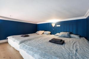 a bedroom with two large beds with blue walls at Wawel Castle View - City Center Suite in Krakow