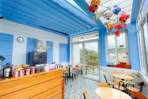 a restaurant with blue walls and tables and chairs at Huong Mai Hotel in Da Lat