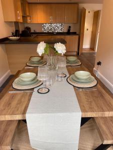 a dining room table with plates and dishes on it at 2 Cherry Tree Cottages in Stock