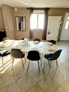 a dining room with a white table and chairs at Gîte des teppes in Alixan