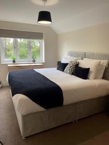 a bedroom with a large bed with pillows on it at 2 Cherry Tree Cottages in Stock