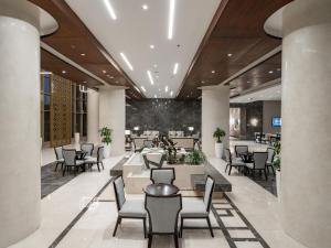 Wirgan Hotel Al Nour في مكة المكرمة: مطعم فيه طاولات وكراسي في لوبي