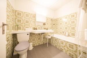 La salle de bains est pourvue de toilettes, d'un lavabo et d'une baignoire. dans l'établissement 3304 Preislich attraktives Studio im alpinen Stil, à Vulpera