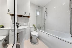 a white bathroom with a toilet and a sink at Modern Gem Brixton Centre Cozy & Comfort Charis City Studio in London