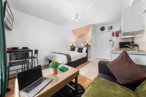 ein Wohnzimmer mit einem Sofa und einem Laptop auf dem Tisch in der Unterkunft Modern Gem Brixton Centre Cozy & Comfort Charis City Studio in London