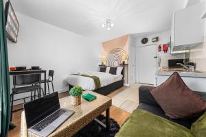 a living room with a couch and a laptop on a table at Modern Studio in Central Brixton, Stylish, Fast Wi-Fi & Parking in London