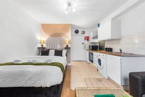a bedroom with a bed and a kitchen at Modern Gem Brixton Centre Cozy & Comfort Charis City Studio in London
