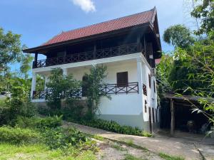 Casa blanca con techo rojo en Mary’s Home Stay, en Luang Prabang