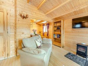 a living room with a couch and a fireplace at Lochinvar - Clydesdale Log Cabin with Hot Tub in Airdrie