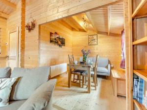 a living room with a couch and a table at Lochinvar - Clydesdale Log Cabin with Hot Tub in Airdrie