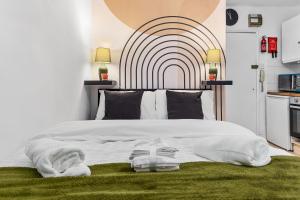 a bedroom with a large white bed with a large headboard at Modern Gem Brixton Centre Cozy & Comfort Charis City Studio in London