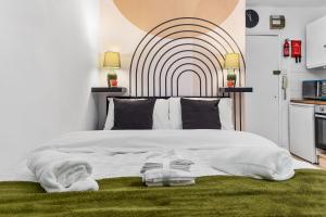 a bedroom with a large white bed with a large headboard at Modern Studio in Central Brixton, Stylish, Fast Wi-Fi & Parking in London