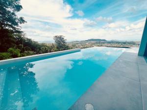 una piscina azul con vistas a la ciudad en Yamu Hills Panoramic Ocean View 6 Bed Luxury Pool Villa - Phuket, en Phuket
