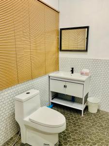 a bathroom with a white toilet and a sink at Ban Sam Bai Thao 