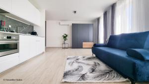 a living room with a blue couch and a kitchen at St. Antoni Suite 3 in Eisenstadt