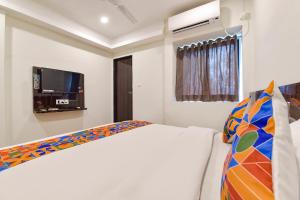 a bedroom with a bed and a flat screen tv at FabHotel Shri Krishna in Vadodara