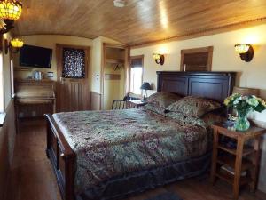 1 dormitorio con 1 cama grande y piano en Clearview Station & Caboose B&B, en Creemore