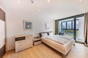 ein Schlafzimmer mit einem Bett und einem großen Fenster in der Unterkunft aika seaside living hotel in Friedrichshafen