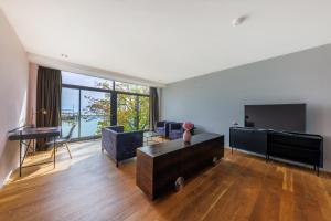 a living room with a large window and a tv at aika seaside living hotel in Friedrichshafen