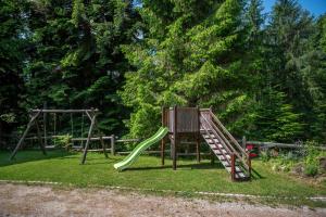 un parco giochi con scivolo verde di Počitniška hiša Koča Dobnik a Lovrenc na Pohorju