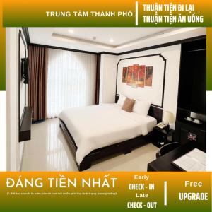 Cette chambre comprend un lit à baldaquin et une télévision. dans l'établissement Phuong Dong Hotel and Apartment, à Quy Nhơn