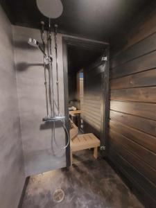 a bathroom with a shower with a bench in it at Lomariihi 1 in Muurame