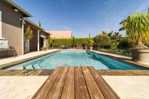 - une piscine avec un banc en bois à côté d'une maison dans l'établissement Villa avec piscine vue mer et montagne, en pleine nature, à Saint-Joseph