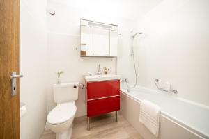 uma casa de banho com um WC branco e um armário vermelho em 4103 Charmantes, neu renoviertes Studio em Vulpera