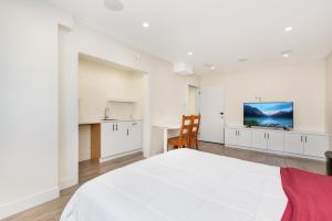 Un dormitorio blanco con una cama grande y una mesa en William Place, en Surrey