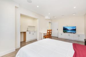 a white bedroom with a large bed and a table at William Place in Surrey