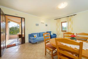 a living room with a blue couch and a table at Villa Ana - Peaceful Location in Marčana