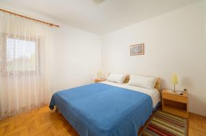 a bedroom with a blue bed and a window at Villa Ana - Peaceful Location in Marčana