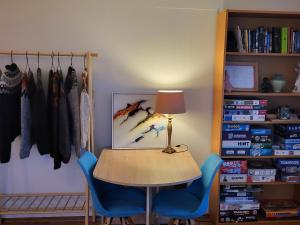 グリンダヴィークにあるGrindavik Guesthouse self check in & outのテーブル(ランプ付)、青い椅子2脚