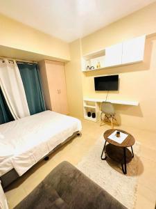 1 dormitorio con cama, mesa y TV en Avida Riala Tower 1, 2nd Floor en Cebú