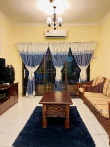een woonkamer met een bank en een salontafel bij D MARINE’ HOMESTAY in Kota Kinabalu