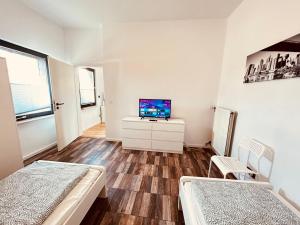 Cette chambre comprend 2 lits et une télévision. dans l'établissement Cozy Apartment near Hamburg, à Stelle
