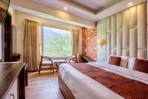 a hotel room with a bed and a table at Katson Blue Manali in Manāli