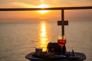 una mesa con un plato de comida y una copa de vino en Hotel Giosue' a mare en Meta