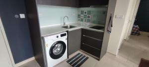 a kitchen with a washing machine and a sink at Kory Homes Relax in Cyberjaya