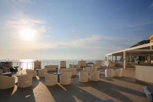 um grupo de cadeiras e mesas brancas num telhado em Hotel Giosue' a mare em Meta