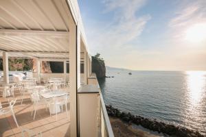 balcone con tavoli e sedie affacciato sull'acqua di Hotel Giosue' a mare Sorrento a Meta