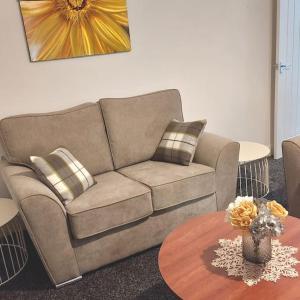 uma sala de estar com um sofá e uma mesa em 4 Double Bedroom House in Accrington sleeps 6 em Accrington