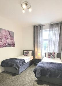 a bedroom with two beds and a window at 4 Double Bedroom House in Accrington sleeps 6 in Accrington