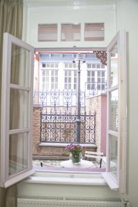 una ventana abierta con un jarrón de flores en el balcón en Apartment On Saadi Str Old Tbilisi, en Tiflis